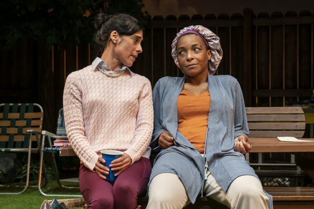 Two women talk on a bench