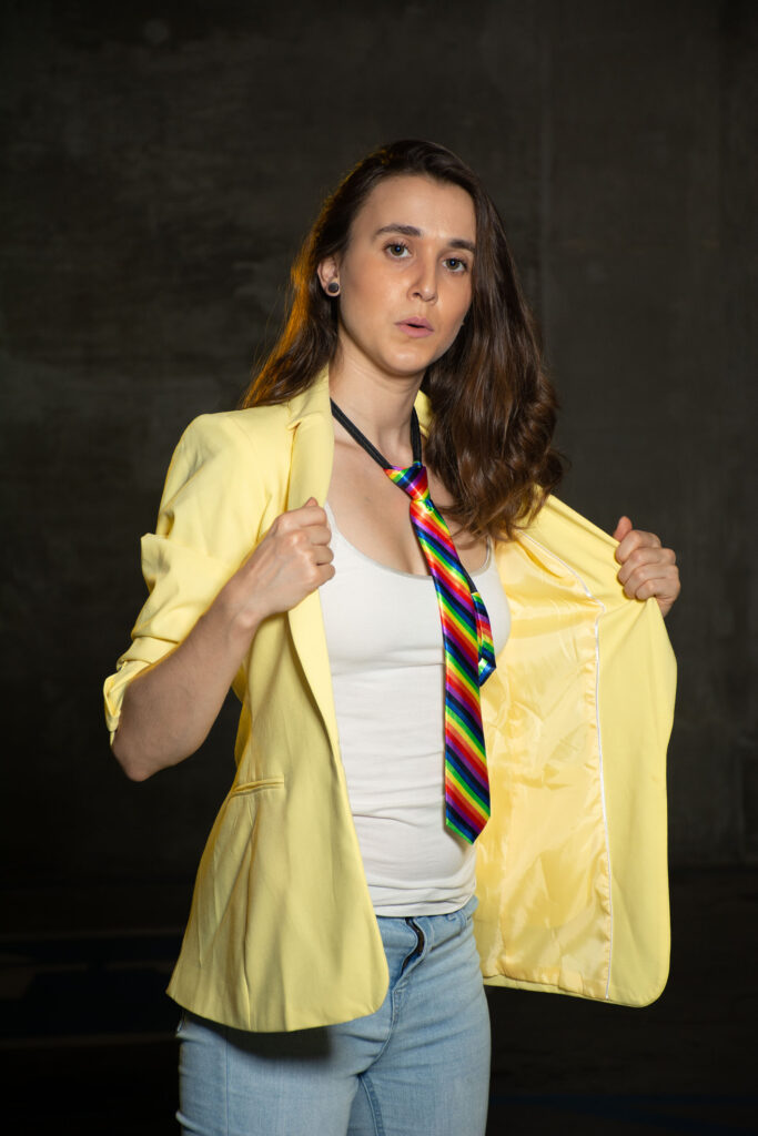 Woman in a rainbow tie and yellow button down shirt