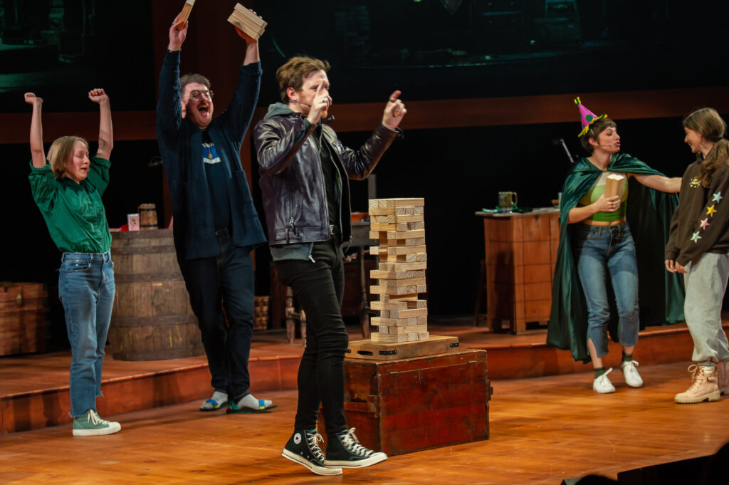 The cast of The Twenty-Sided Tavern and one audience member around a game of Jenga
